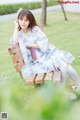 A woman sitting on a bench in a park.