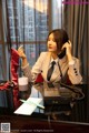 A woman sitting at a desk talking on a phone.