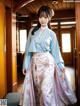 A woman in a blue and pink hanbok standing in a doorway.