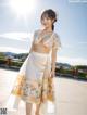 A woman in a white skirt and a floral top posing for the camera.