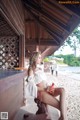 A woman sitting on a wooden bench on the beach.