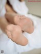 A close up of a person's bare feet on a bed.