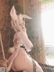 A woman in a bunny costume sitting on a swing.