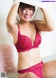 A woman in a red bra and panties posing for a picture.