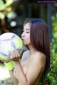 A woman holding a soccer ball in her hands.